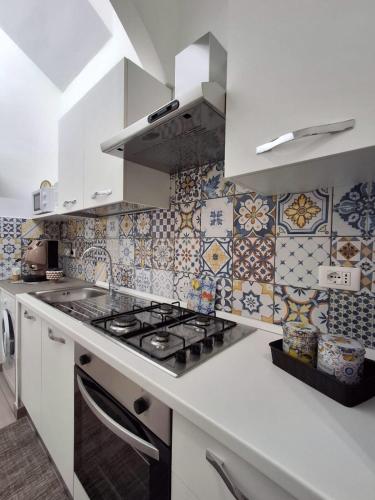 a kitchen with a stove and tiles on the wall at Casa Carruvedda in Avola