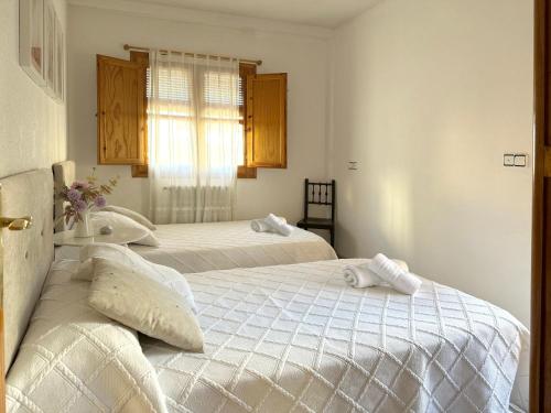 a bedroom with two beds with towels on them at VUT Casa Orrios, en el centro de Alcañiz. in Alcañiz