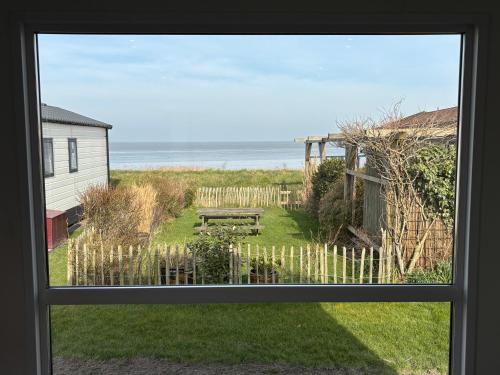 a window view of a yard with a picnic table at Chalet Luuk & Pleun aan Zee in Westerland