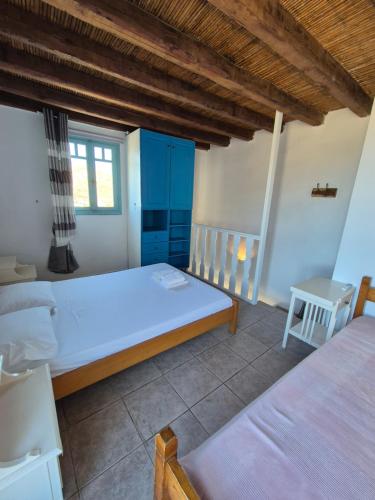 a bedroom with a large white bed and blue cabinets at Amygdaliá - Chora view house in Chora Folegandros