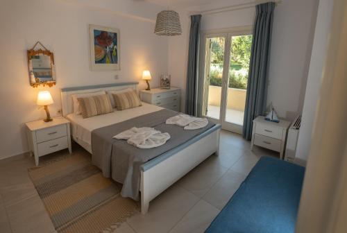 a bedroom with a bed with two lamps and a window at Villa Stefania in Agios Georgios Pagon