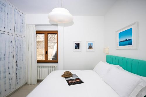 a white bedroom with a bed and a window at Villa Leonardo in the heart of Positano in Positano