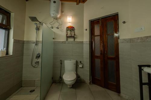 a bathroom with a toilet and a shower at SaffronStays Casa Octavia in Bhīm Tāl