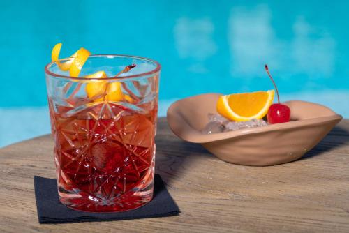 a drink on a table with a bowl of fruit at Malena Hotel & Suites - Adults Only by Omilos Hotels in Amoudara Herakliou
