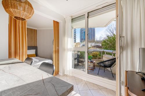 a bedroom with a bed and a view of a balcony at The Lake Aurora Suite - Duke Housing in Créteil