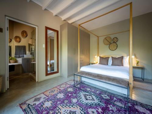 a bedroom with a canopy bed and a rug at eKhaya Bush Lodge in Hoedspruit