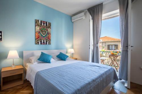 a blue bedroom with a bed and a balcony at Apartments Marija in Supetar