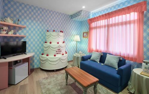 a living room with a blue couch and a cake at Kitsch Hotel in Bangkok