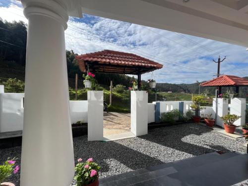 a white fence with a gazebo in a yard at Fortune Retreats in Ooty