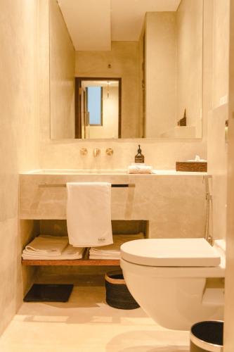 a bathroom with a toilet and a sink and a mirror at Harding Boutique Hotel in Ahangama