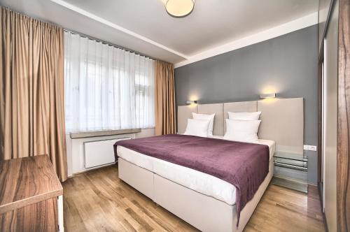 プラハにあるArt Residence Krocinovaのベッドルーム(紫の毛布を使用した大型ベッド1台付)