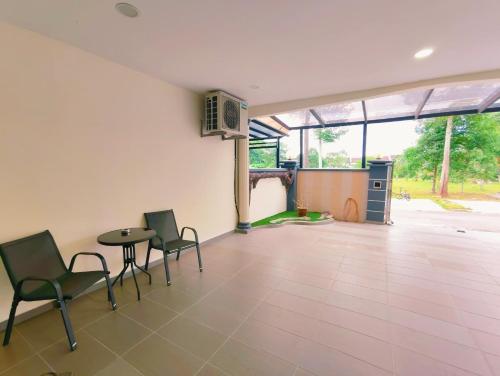 un soggiorno con sedie, tavolo e tavolo di Area Bandar Putra Kulai 4-6BR near AEON IOI Airport a Kulai