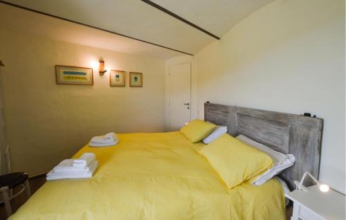 a bedroom with a yellow bed with a wooden headboard at Gorgeous Home In Murazzano With Wifi in Murazzano