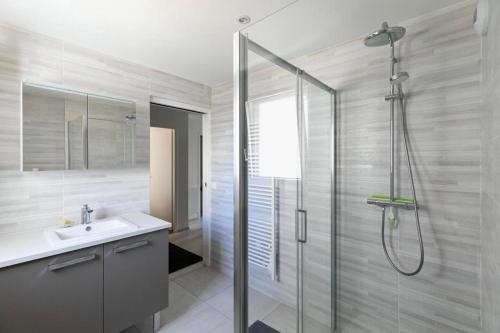 une salle de bain avec une douche en verre et un lavabo dans l'établissement La Villa Ker Mi'mil, à Saint-Gildas-de-Rhuys