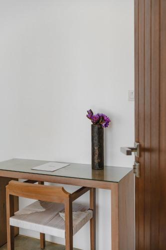 a table with a vase with purple flowers on it at Harding Boutique Hotel in Ahangama