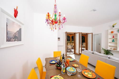 a dining room with a table and yellow chairs at Villa Leonardo in the heart of Positano in Positano