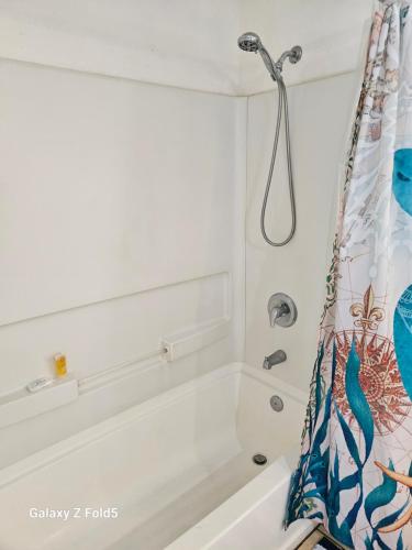 a bathroom with a bath tub with a shower curtain at Yonegan Maui Getaways - Haiku in Haiku
