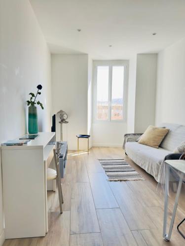 un salon blanc avec un canapé et une table dans l'établissement Appartement Roi Jérôme - Hypercentre, à Ajaccio