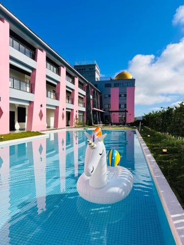 a pool with an inflatable unicorn in front of a building at 沐舍-蜜滋賀溫泉飯店 in Ruisui
