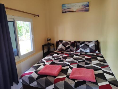 a bedroom with a bed with two pillows on it at turtles place -Chay's Bungalow in San Francisco
