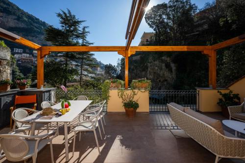 a patio with a white table and chairs on it at Villa Leonardo in the heart of Positano in Positano