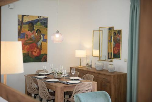 a dining room with a table with chairs and a painting at Villa Stefania in Agios Georgios Pagon