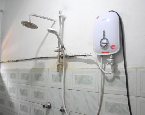 a shower with a hose attached to a wall at The Dew Drop View in Nuwara Eliya