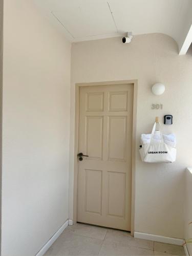 a hallway with a door and a bag on the wall at Urban room samed in Ko Samed