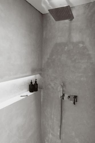 a bathroom with a shower with two bottles on a shelf at Harding Boutique Hotel in Ahangama
