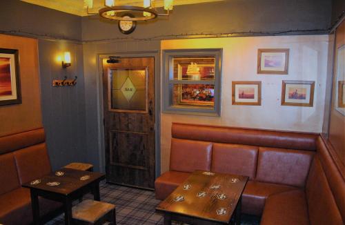 a bar with a bench and a table and a door at The Kirkcudbright Bay Hotel in Kirkcudbright