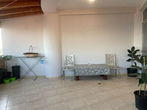 a room with two chairs and a table and plants at Hotel Kloest in Durrës