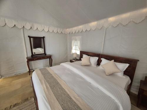 a bedroom with a large bed and a mirror at Royal Adventure Jaisalmer Resort in Jaisalmer