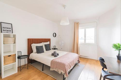 une chambre blanche avec un lit et une table dans l'établissement Le Jaurès - moderne 2 chambres - hyper centre, à Reims