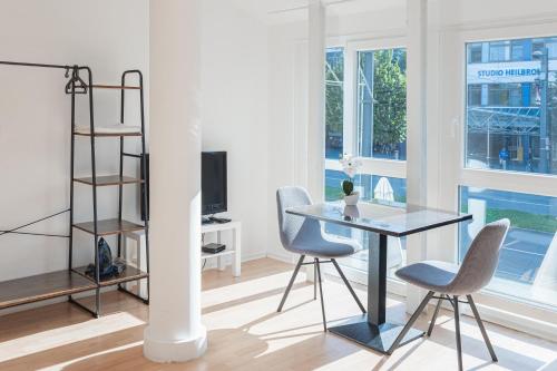 een kamer met een tafel en stoelen en een plank bij Apartments EFDE GmbH in Heilbronn