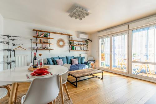 un salon avec une table et un canapé dans l'établissement Transports, parking, A/C & equipped for long stays, à Saint-Ouen