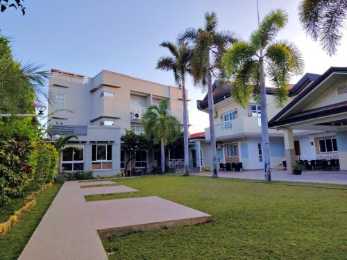 a courtyard with palm trees in front of a building at Ambien's Place Residential Hotel in Dagupan
