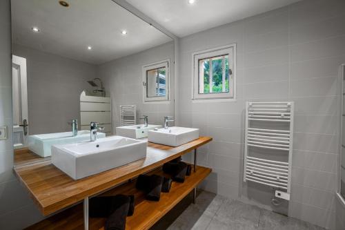 een badkamer met twee wastafels en twee spiegels bij Villa Carry Piscine Sauna Jacuzzi in Carry-le-Rouet