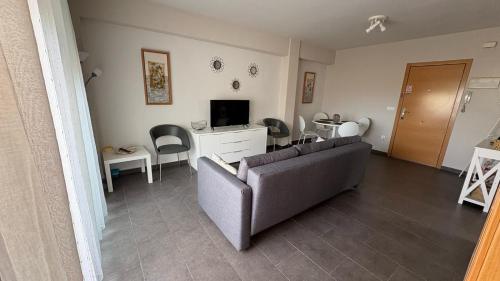 バレンシアにあるApartment near the beachのソファとテーブルと椅子のあるリビングルーム