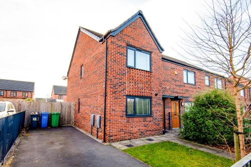 a brick house with a driveway in front of it at Manchester Cityside Deluxe Stay - 3 Bedroom House Great for Family with Free Parking & Garden in Manchester