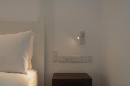 a bedroom with a bed and a light on the wall at Harding Boutique Hotel in Ahangama