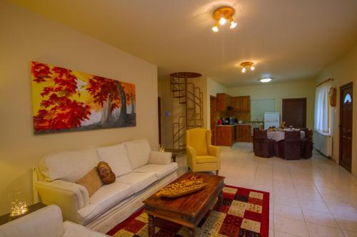 a living room with a white couch and a table at VILLa PERSEPHONE in Platres