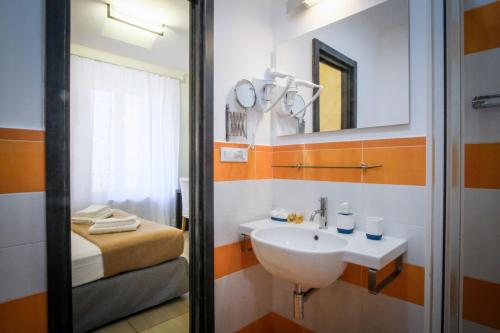 a bathroom with a sink and a bed at Mocenigo Vatican Suites in Rome