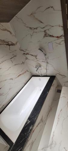 a marble bathroom with a white sink in a room at Rudraksh Lakhisarai in Luckeesarai