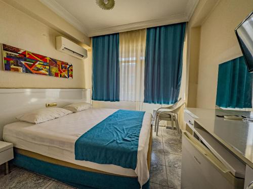 a small bedroom with a bed and a window at Sazak Hotel in Manavgat
