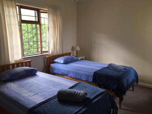 a bedroom with two beds and a window at Petes Beach House in Port Shepstone