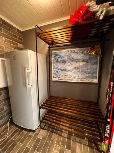 a kitchen with a refrigerator and a shelf next to a wall at Ustedalen Lodge in Geilo