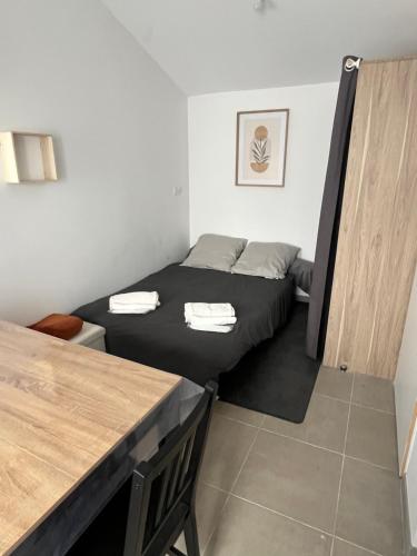 une petite chambre avec deux lits et une table dans l'établissement Studio, à Commequiers