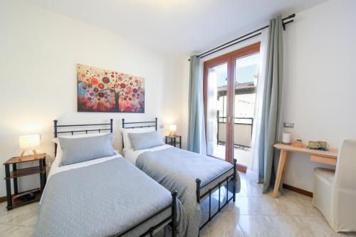 two beds in a room with a window at Orio Stay&Fly in Orio al Serio