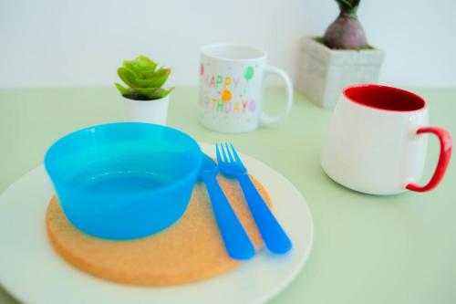 a plate with a blue bowl and fork and a cup at -Garden View- Mount Austin Aeon IKEA 10 mins - A13A in Johor Bahru