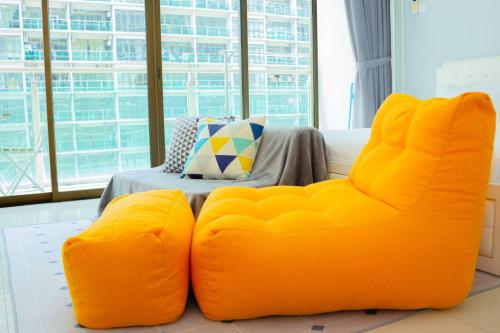 an orange couch sitting in front of a window at -Garden View- Mount Austin Aeon IKEA 10 mins - A13A in Johor Bahru